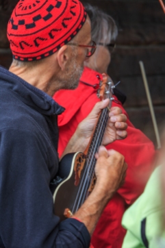 the next pictures show musicians meeting in a gateway with people gathering around, listening to them. A mixture of bigger pictures and closeups.